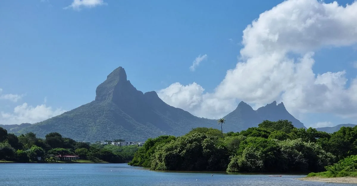 Capture des montagnes et du lagon emblématiques de l'île Maurice sous un ciel bleu clair.